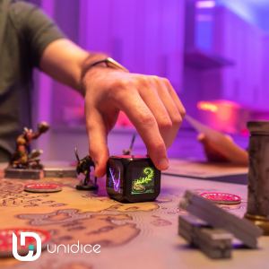 unidice gets played o a boardgame. hand holding the unidice.